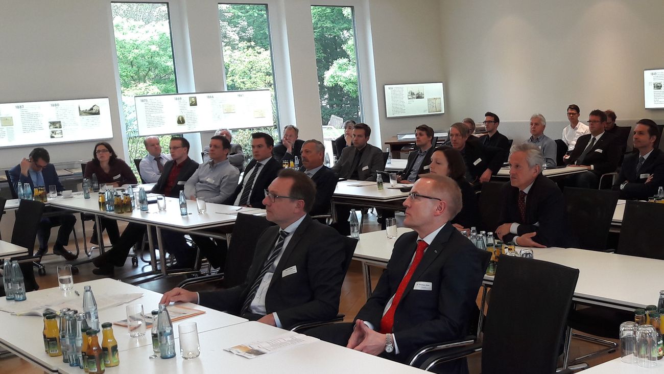 Teilnehmerinnen und Teilnehmer an Konferenztischen