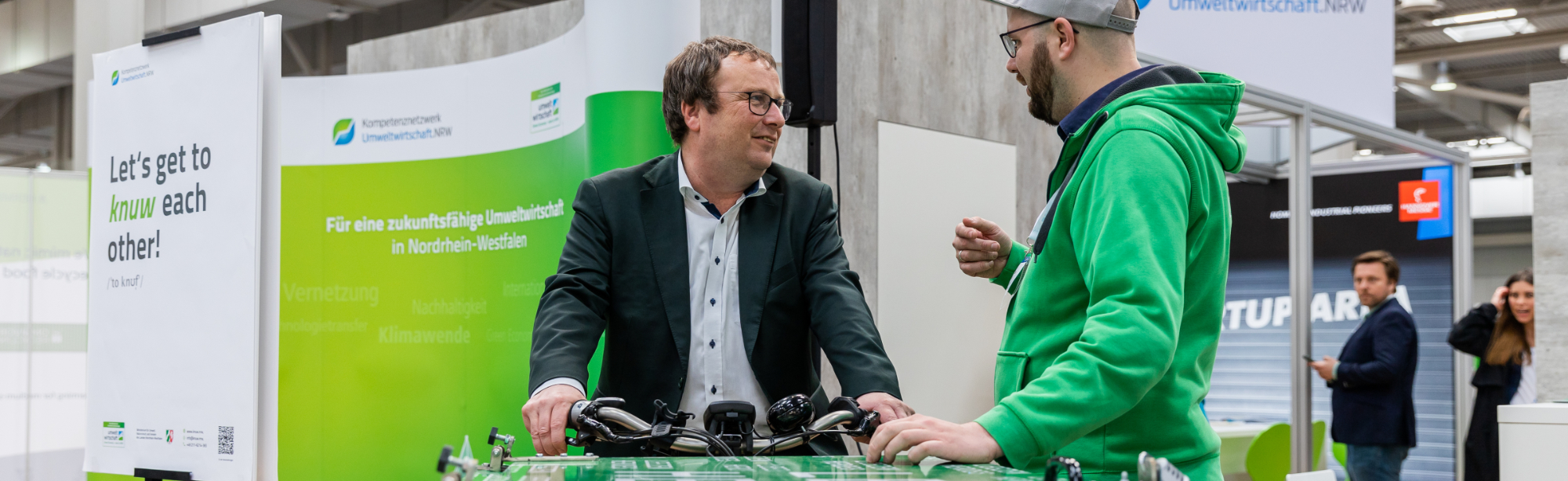 NRW-Umweltminister Oliver Krischer auf einem Lastenfahrrad am Messestand
