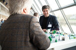 Zwei Männer an einem Legomodell mit Straßen und Schranken