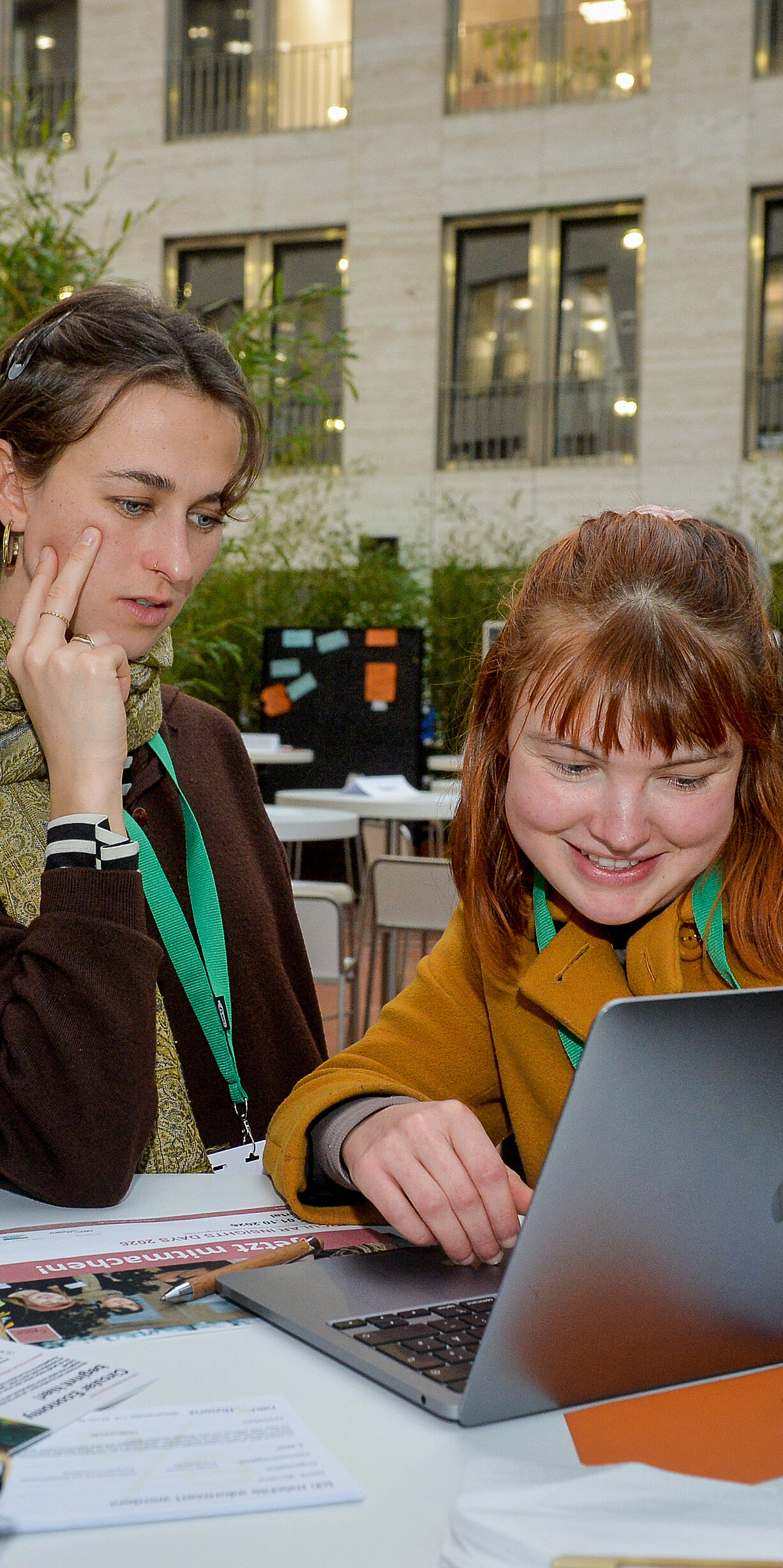 Bei der Ausstellung: Eine Gruppe von Frauen betrachtet etwas auf einem Laptop
