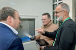 Minister Krischer mit weiteren Personen betrachtet den Ausgabeschacht der mobilen Paketstation