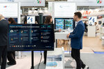 Ein Monitor zeigt KI-Lösungen der Wasserwirtschaft am Gemeinschaftsstand, im Hintergrund mehrere Personen