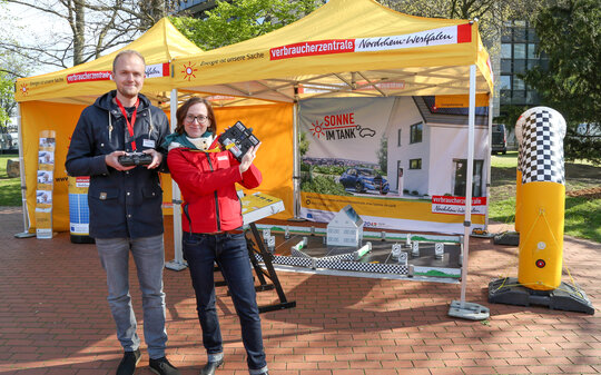 Zwei Menschen vor orangenem  Ausstellungszelt