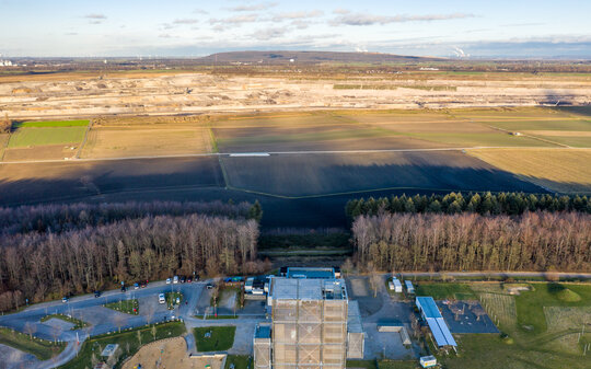 Luftaufnahme zeigt die Stahlkonstruktion des Aussichtturm Indemann mit Blick über den Tagebau Inden bis zur Sophienhöhe, der Abraumhalde am Tagebau Hambach.