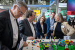 Minister Oliver Krischer betrachtet mit mehreren Personen ein Stadtmodell auf der Messe