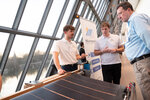 Drei Männer im Gespräch am Stand von Solarmarkise, im Vordergrund eine Demomarkise