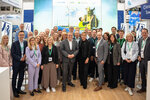 Gruppenbild mit Ministerin Neubaur und Minister Krischer am Gemeinschaftsstand zusammen mit Ausstellenden und Personen des Kompetenznetzwerks Umweltwirtschaft.NRW