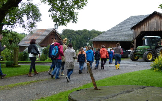 Eine Gruppe junger Menschen besucht einen Bauernhof.