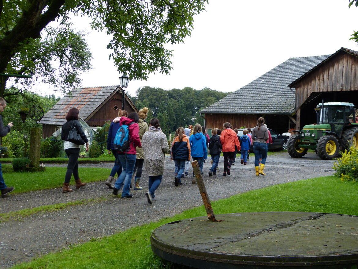 Eine Gruppe junger Menschen besucht einen Bauernhof.