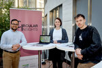 Eine Gruppe von drei Personen rund um den Ausstellungsstand von Circular Insights