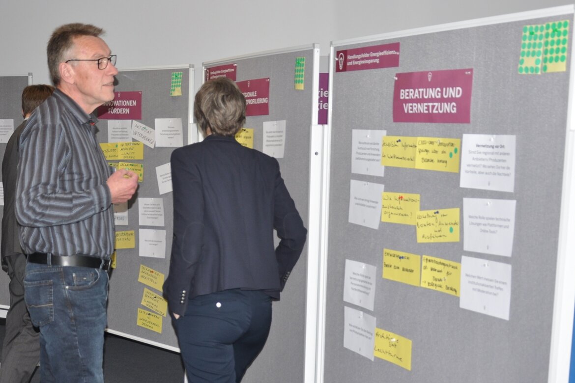 Konferenzteilnehmer begutachtet aufmerksam die Plakatwand.