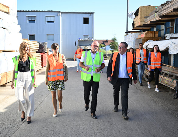 Minister Krischer und eine Gruppe von Begleitpersonen auf dem Betriebsgelände, alle tragen Warnwesten