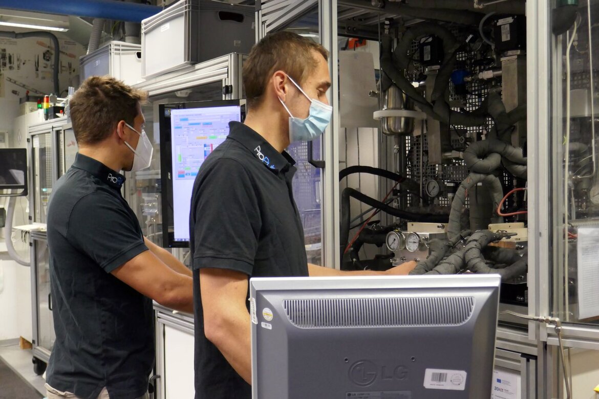 Zwei Männer stehen an einem Laboraufbau