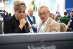 Ein Mann zeigt Ministerin Neubaur etwas auf einem Bildschirm