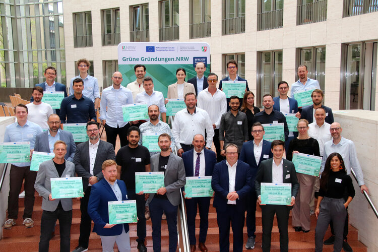 Gruppenbild mit Minister, die Gründerinnen und Gründer halten symbolische Förderschecks in die Kamera