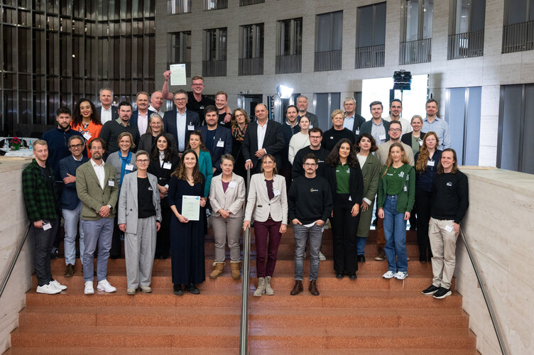 Gruppenbild auf einer Treppe im Atrium des Ministeriums