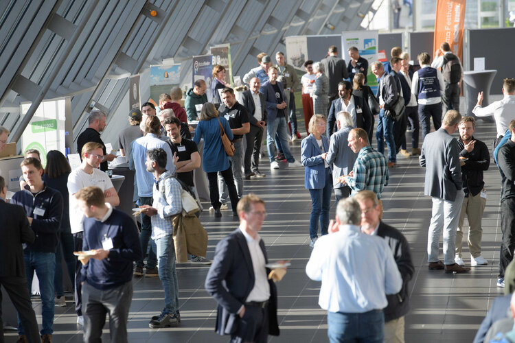 Viele Menschen in einem hellen Atrium mit Ausstellungsständen