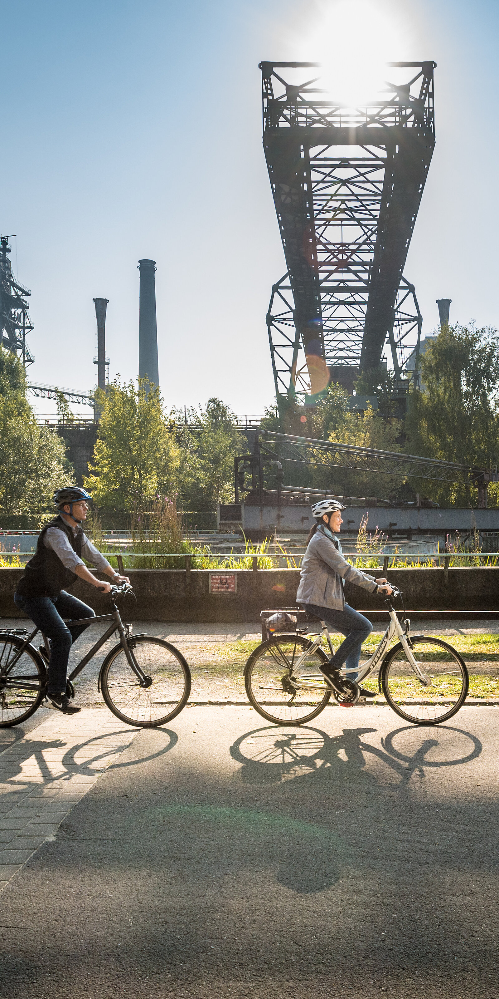Zwei Radfahrer vor einer Industriekulisse in Nordrhein-Westfalen