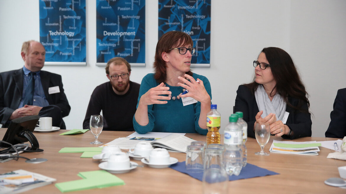 Zwei Frauen und zwei Männer sitzen am Tisch und diskutieren angeregt.