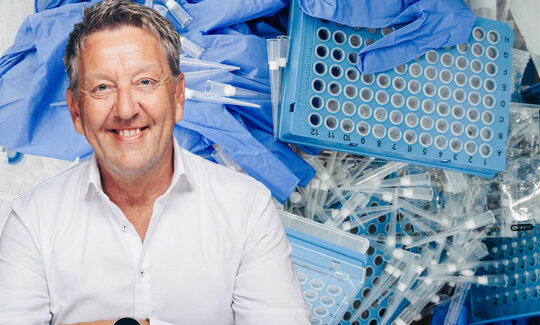 Portraitaufnahme von Michael Schmitz vor einem Haufen medizinischer Wegwerfprodukte
