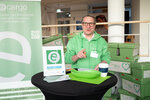 Ein Mann in grüner Kleidung betreut den Stand von ecargo