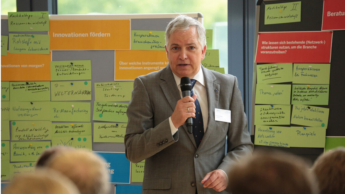 Prof. Dr. Christoph Wetter (FH Münster) steht vor der Projekttafel und hält einen Vortrag.