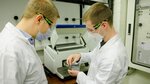Zwei Männer in Laborkitteln vor einem Laborgerät