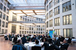 Das Publikum an runden Tischen im Atrium des Ministeriums