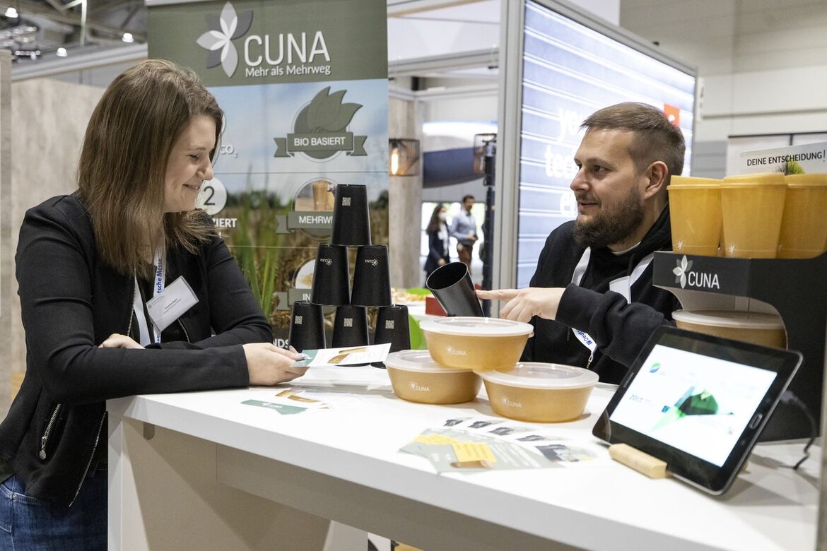 Ein Mann und eine Frau am Messestand von CUNA