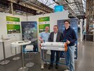 Minister Krischer mit zwei jungen Männern von Plastic Fischer am Gemeinschaftsstand
