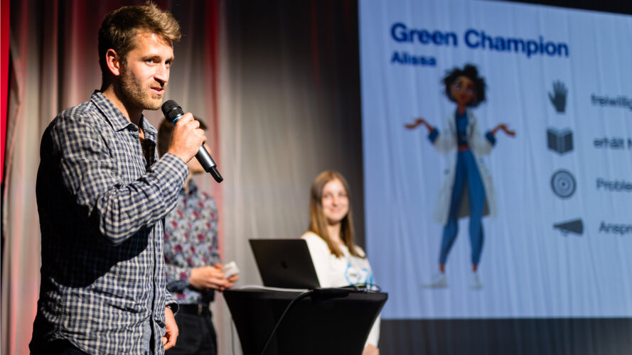 Ein junger Mann am Rednerpult hält eine Präsentation