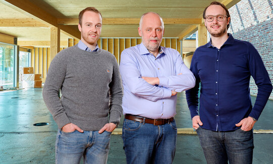 Ein Gruppenbild: der Unternehmensgründer stehe in der Mitte, seine Söhne links und rechts von ihm